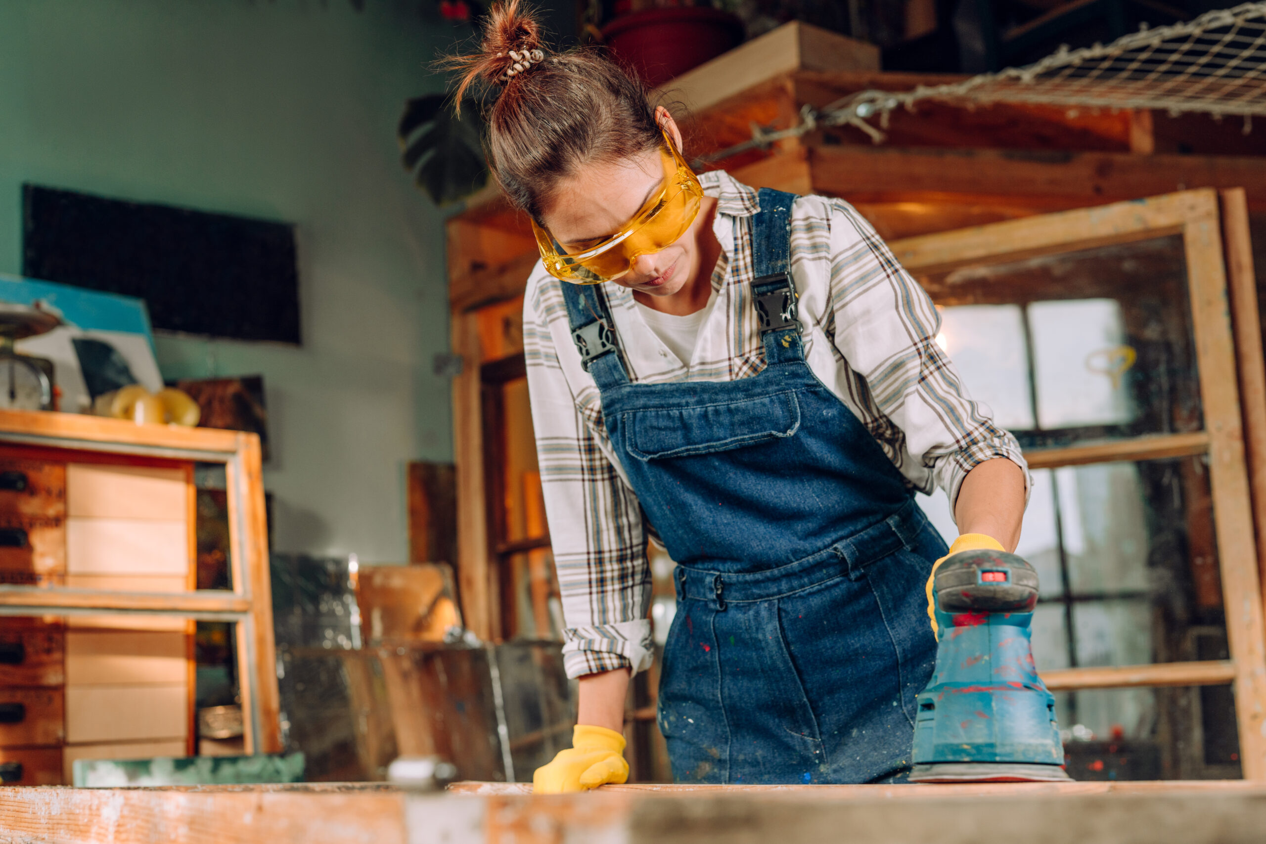woman wearing protective glasses working in a workshop