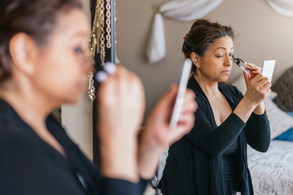 Attractive woman curling her eyelashes