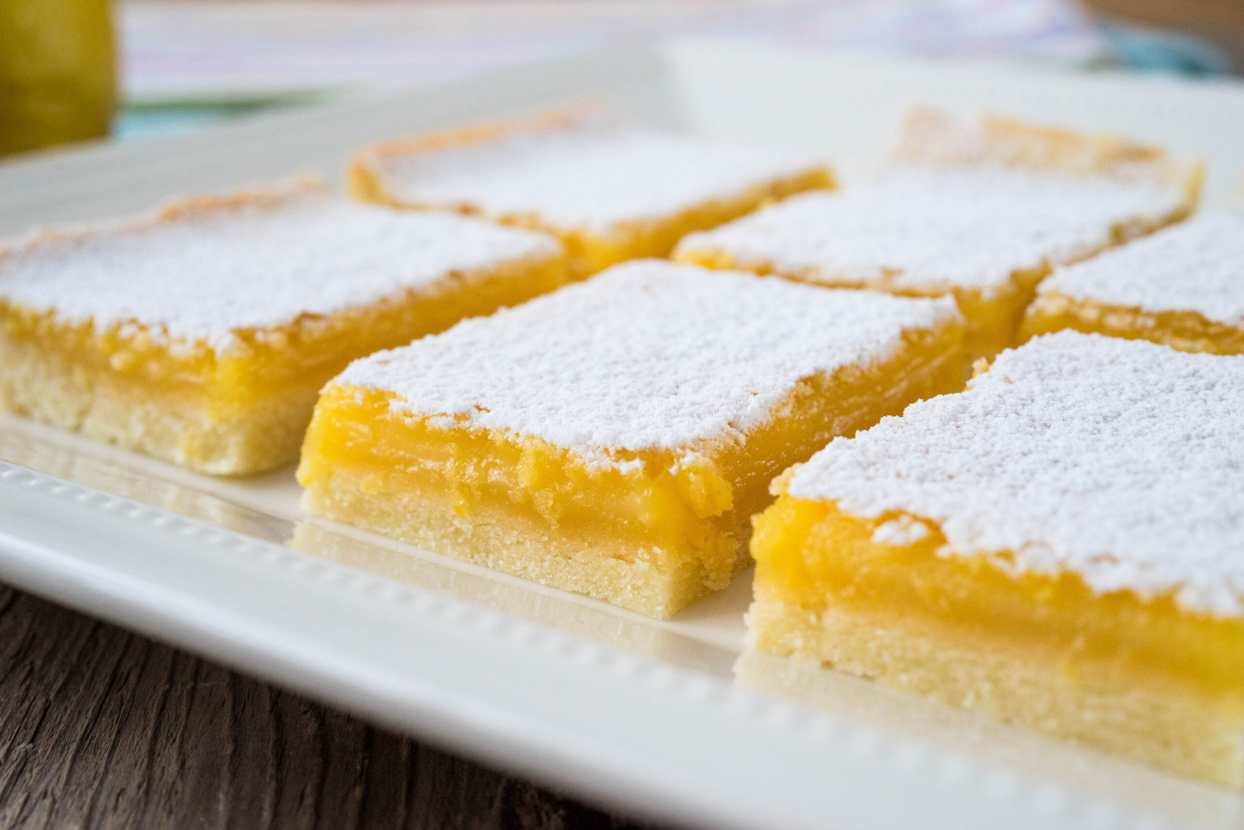 freshly baked lemon bars with powdered sugar on dish
