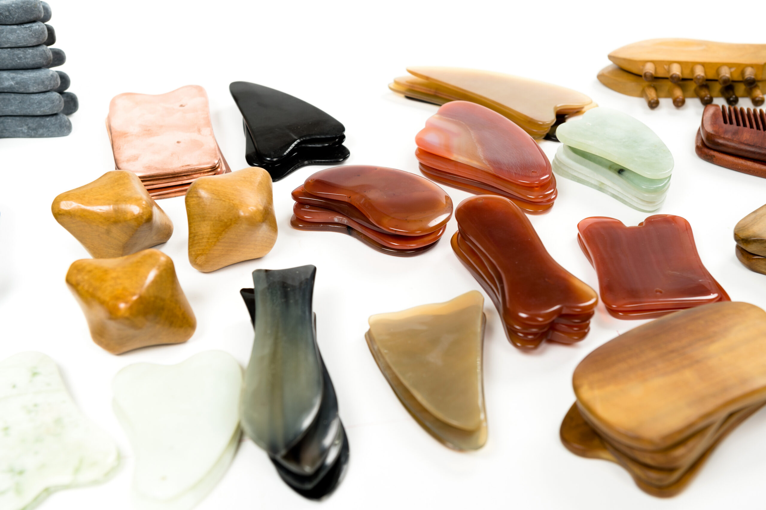 Jade gua sha tools,big set of tools for spa treatments Jade massage stone on white background.Big set of Gua Sha jade scraping massage tool. Collection of different shape natural rose quartz stone.