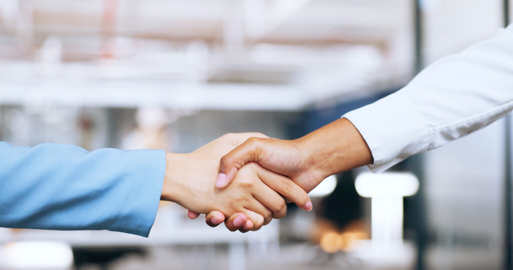 Corporate, partnership and b2b handshake of business people for professional agreement together. Cooperation, welcome or thank you of interracial women employees shaking hands in workplace.