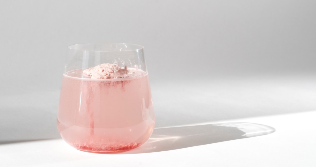 pink collagen supplement drink in a glass
